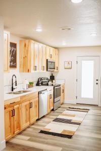a kitchen with white appliances and wooden cabinets at Creekside Cabins- Birch stylish stay w views in McCammon