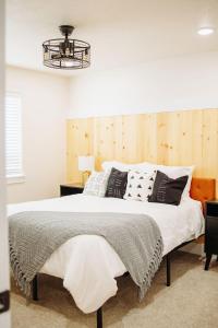 a bedroom with a large bed with black and white pillows at Creekside Cabins- Birch stylish stay w views in McCammon