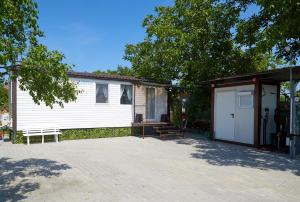 a house with a garage and a bench next to it at Mobile Home CARMINO in Turda