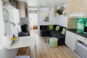 a small living room with a couch and a table at Mobile Home CARMINO in Turda