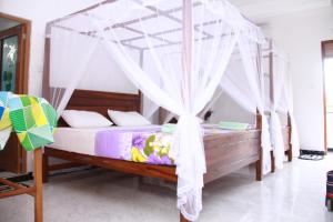 1 cama con dosel en una habitación en Orchid Rest, en Mirissa