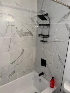 a white bathroom with a white tub and marble walls at Spacious 4-Bedroom Retreat in Kankakee, IL in Kankakee