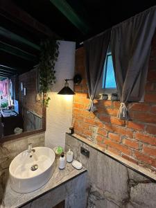 a bathroom with a sink and a brick wall at Smestaj sa bazenom Sunny Hill in Smederevska Palanka