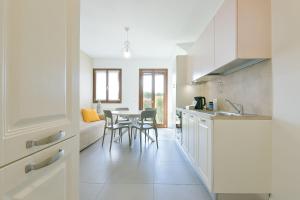 a kitchen with white cabinets and a table with chairs at Queen Venice Fly Apartments in Campalto