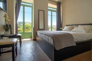 a bedroom with a bed and a table and windows at Ancient Agora Plaka in Athens +77 photos