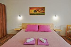 a bedroom with a bed with pink sheets and pink pillows at Holiday house Green Oasis in Otočac