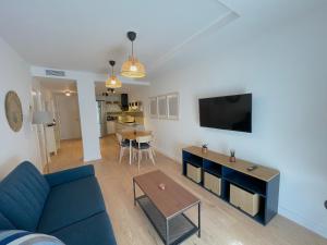 a living room with a blue couch and a table at Apartamento La Botica garaje incluido in Huelva