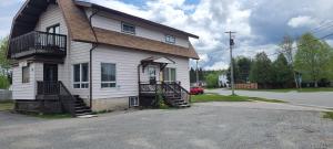 a white house with a brown roof and stairs at Kozy Casa in Wawa