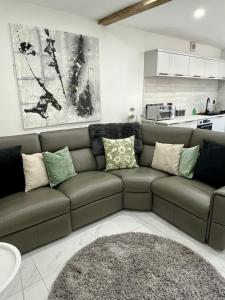 a living room with a brown couch with pillows at Lewys Tai Bach in Aberaman +17 photos