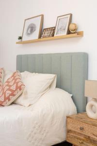 a bedroom with a bed with two pictures on a shelf at Maré Baixa Oceanside Apartment in Nazaré