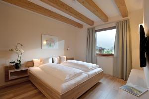 sypialnia z dużym białym łóżkiem i oknem w obiekcie Resort Tirol Brixen am Sonnenplateau w mieście Brixen im Thale