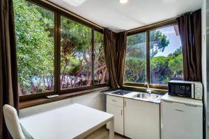 eine kleine Küche mit einem Waschbecken und Fenstern in der Unterkunft Villa Costa Marbella in Marbella