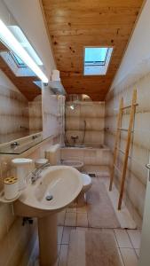 un bagno con lavandino, WC e vasca di Apartmani Cocolo a Poreč (Parenzo)