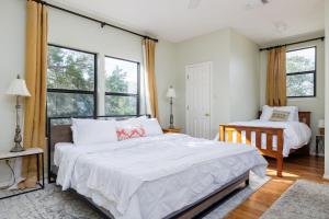 a bedroom with a large bed and two windows at Unique Victorian Estate Pets Welcome Pool BBQ Picnic Privacy in Dripping Springs +38 photos