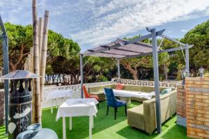 eine Terrasse mit einer Pergola sowie Tischen und Stühlen in der Unterkunft Villa Costa Marbella in Marbella