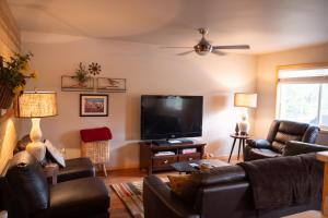 a living room with couches and a flat screen tv at SEWARD APARTMENT in Seward