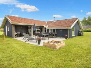 een huis met een patio en een tafel en stoelen bij Luxury Pool House near Beach - By Traum Ferienwohnungen in Nordborg