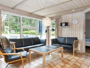een woonkamer met een bank en een tafel bij Luxury Pool House near Beach - By Traum Ferienwohnungen in Nordborg