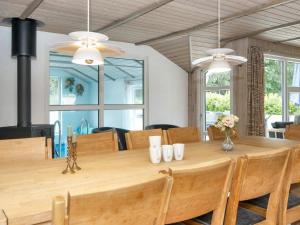 een eetkamer met een grote houten tafel bij Luxury Pool House near Beach - By Traum Ferienwohnungen in Nordborg