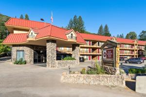 Un hotel con techo rojo y estacionamiento. en Best Western Plus Yosemite Way Station, en Mariposa