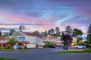 a building in a parking lot with a church at Best Western Rockland in Rockland