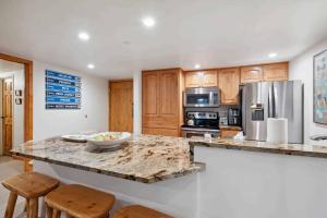 a kitchen with a marble counter top and wooden cabinets at Lodge at Lionshead 110-100 in Vail
