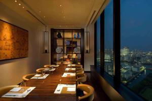 a long table in a restaurant with a view at Conrad Tokyo in Tokyo