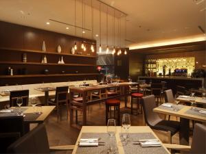 a restaurant with tables and chairs and a bar at Conrad Tokyo in Tokyo