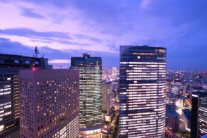a group of tall buildings in a city at night at Conrad Tokyo in Tokyo