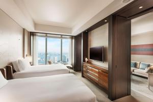 a hotel room with two beds and a tv at Conrad Tokyo in Tokyo