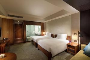 a hotel room with two beds and a bathroom at Conrad Tokyo in Tokyo