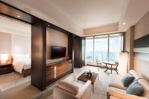 a hotel room with a bed and a living room at Conrad Tokyo in Tokyo