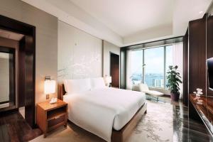 a bedroom with a white bed and a large window at Conrad Tokyo in Tokyo