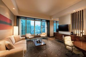 a living room with a couch and a tv at Conrad Tokyo in Tokyo