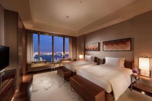 a hotel room with two beds and a television at Conrad Tokyo in Tokyo