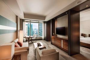 a living room with a couch and a bed and a television at Conrad Tokyo in Tokyo