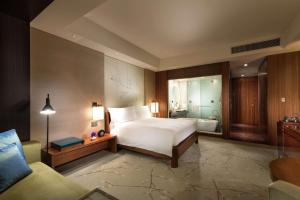 a bedroom with a bed and a tub in a room at Conrad Tokyo in Tokyo