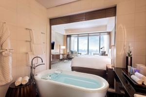 a bathroom with a bed and a tub in a room at Conrad Tokyo in Tokyo