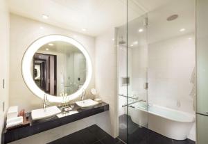 a bathroom with two sinks and a mirror and a tub at Conrad Tokyo in Tokyo