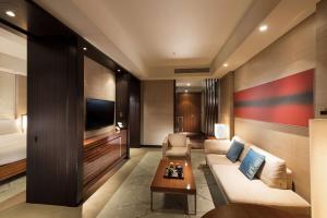 a living room with a couch and a bed at Conrad Tokyo in Tokyo