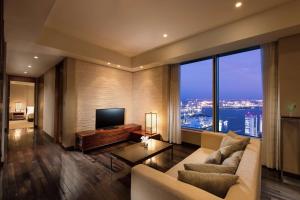 a living room with a couch and a television at Conrad Tokyo in Tokyo