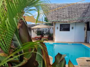 a villa with a pool and a house at Villa Kumi in Nungwi