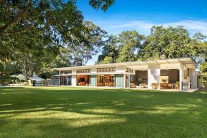 a house with a green lawn in front of it at Pine Mountain - luxury rural estate with pool in Binna Burra