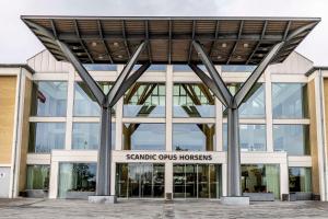 een groot gebouw met een bord ervoor bij Scandic Opus Horsens in Horsens
