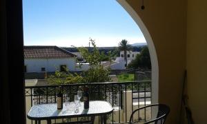 a balcony with two tables and a view of a city at Villa Kiki in Lachania