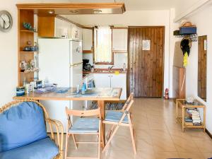una cucina con tavolo, sedie e frigorifero di Steve's Siviri's Apartment a Siviri