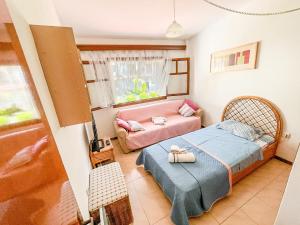 una piccola camera da letto con un letto e un divano di Steve's Siviri's Apartment a Siviri