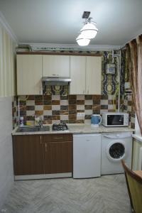 a kitchen with a dishwasher sink and a microwave at Apartment Decebal in Chişinău