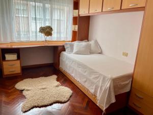 a bedroom with a bed with a window and a rug at Lar da Amarella in Ribeira