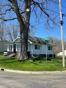 a street sign in front of a house with a tree at Albert Lea revival in Albert Lea